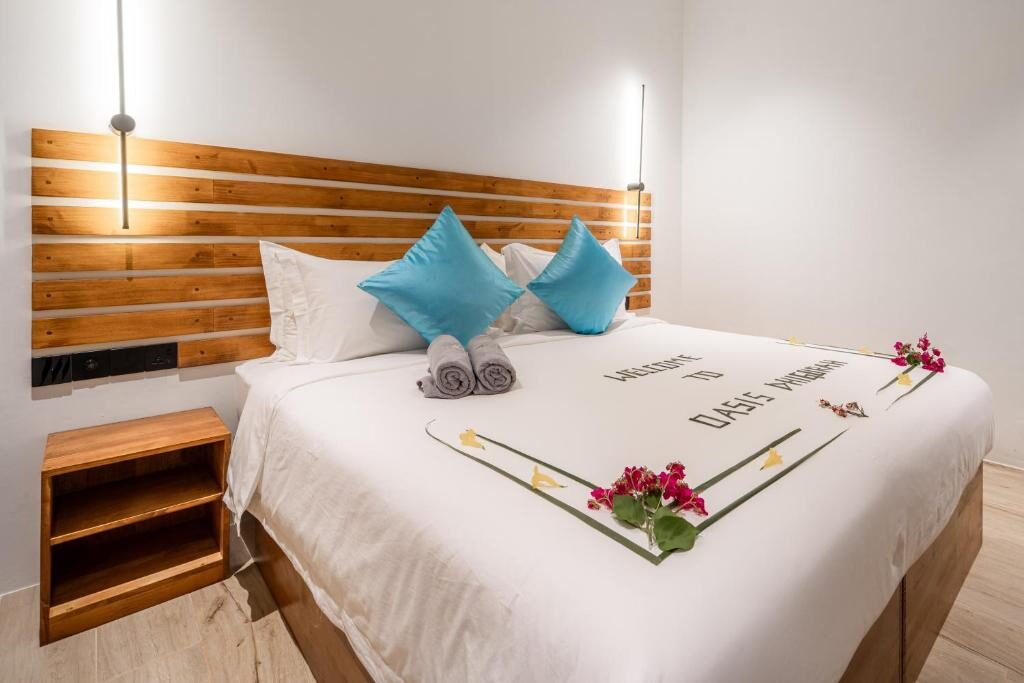 Deluxe Double Room with wooden headboard and king bed at Oasis Dhigurah